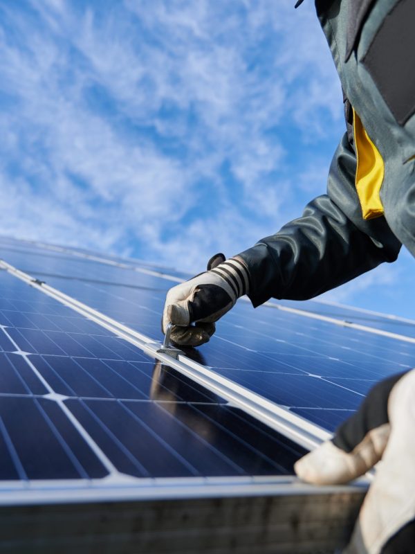 Male worker repairing photovoltaic solar panel.
